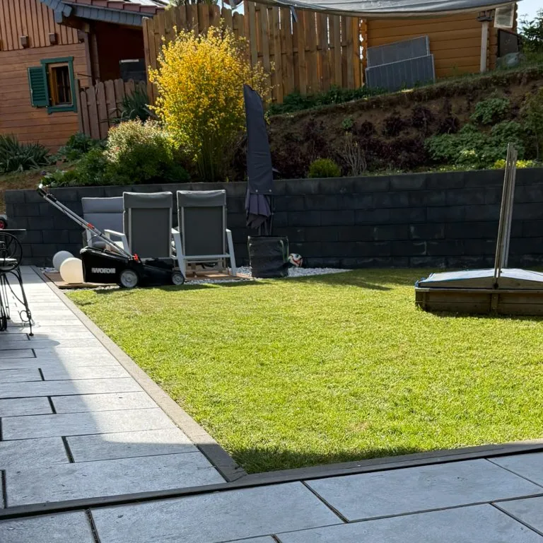 Gepflegter Rasen mit Terrasse und Randeinfassung